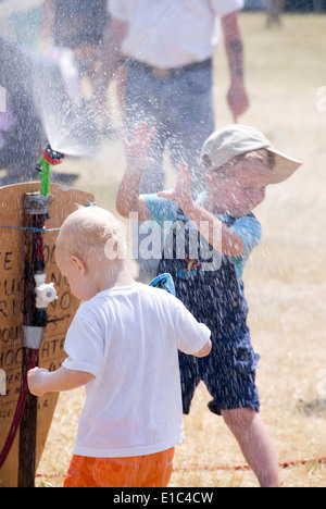 Tewkesbury Mittelalterfest, Gloucester UK Juli 2013: Kinder spielen im Wasser Abkühlung sprühen an einem sehr warmen sonnigen Tag an der th Stockfoto