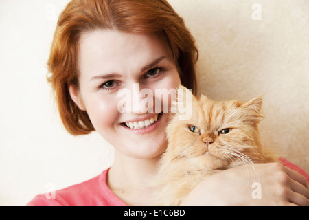 Junge Frau mit Perserkatze Stockfoto