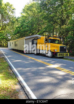 Ein Mobilheim auf einer einspurigen Landstraße im ländlichen USA gezogen wird Stockfoto