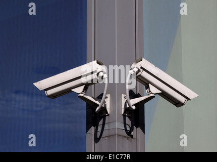Zwei Überwachungskameras hängen an der Gebäudewand Stockfoto