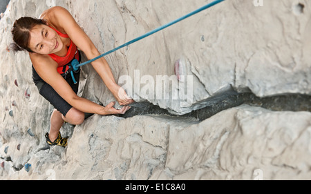 Frau, die künstliche Riss an indoor Kletterhalle Klettern Stockfoto