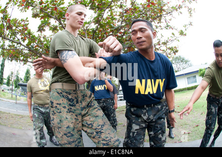 U.S. Marine Corps Lance Cpl. Kenneth Pollard, links, Pazifik Flotte Anti-Terrorism Security Team (schnell), zugewiesen lehrt Fili Stockfoto