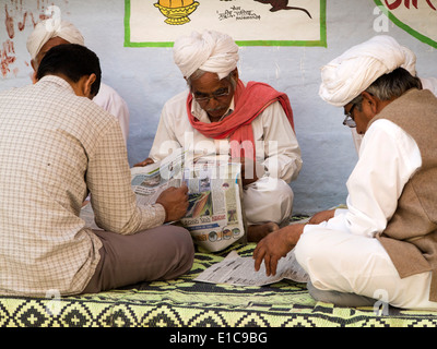 Indien, Rajasthan, Jaisalmer, alte Männer saßen Lesung Hindi Lnguage Zeitungen im Schatten Stockfoto