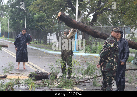 Ein philippinischer Flieger schneidet sich ein umgestürzter Baum 19. Oktober 2010, während der Bergungsarbeiten nach Taifun Megi auf Clark Air Base, Phil Stockfoto