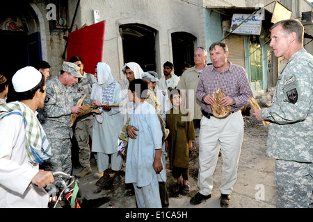 General David H. Petraeus bricht Brot mit einer Gruppe von jungen vor einer Bäckerei in einem Markt der Stadt Kandahar während des Gehens Bereich fr Stockfoto