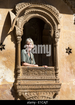 Indien, Rajasthan, Jaisalmer, Patwon Ki Haveli, Frau Tourist im dekorativ geschnitzten Sandstein-Fenster Stockfoto