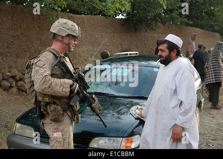 Ein US-Marine mit dem 1. Bataillon, 7. Marineregiment, spricht für eine lokale Dorfbewohner während einer Mission zur Niederschlagung von Aufständen 16. Mai 2014 in Larr Dorf, Provinz Helmand, Afghanistan. Stockfoto