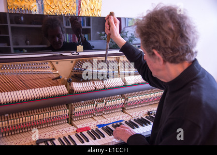 Tuner bei der Arbeit mit Ratsche am Klavier Stockfoto