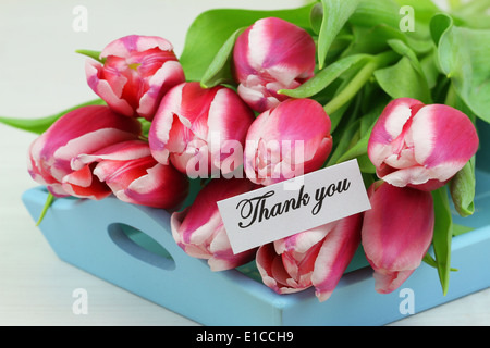 Dankeschön-Karte mit rosa Tulpen auf blauen Holztablett Stockfoto