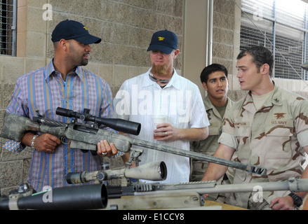 US Navy Special Warfare Operator 1. Klasse Thompson, Recht, erklärt Details ein Scharfschützengewehr, Major League Baseball Playe Stockfoto