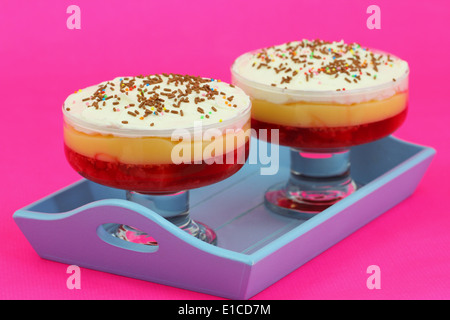 Erdbeer-Trifle Dessert auf blauen Tablett auf rosa Hintergrund Stockfoto