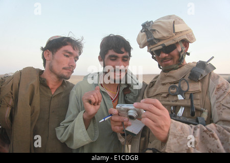 US Navy Chief Petty Officer Angelito Campano zeigt afghanischen Männer ihre Foto während einer medizinischen bürgerschaftliches Engagement-Mission in der Helman Stockfoto