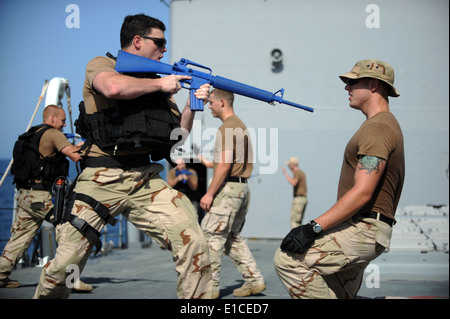 US Navy Lt. j.g Kevin Snodgrass befiehlt seinem Trainingspartner an Deck während der Aufbewahrung von Waffen Übungen an Bord Stockfoto