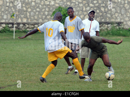 US Marine Corps Gunnery Sgt. Gaw Jones Manöver einen Fußball um einen Gegner bei einem Freundschaftsspiel gegen Irie Stockfoto
