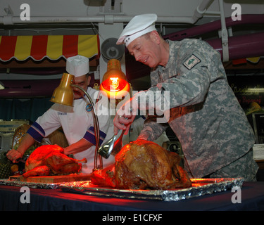 US Armee General David H. Petraeus, Kommandeur des US Central Command, schnitzt einen Truthahn während Thanksgiving-Dinner an Bord der airc Stockfoto