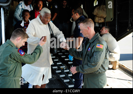 US Air Force Captain Philip Noland, links, und techn. Sgt. Brian Ghent helfen eine ältere Erdbeben in Haiti-Überlebende die Rampe hinunter Stockfoto