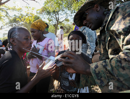 US Marine Corps Sgt. Mark Leuis, von 3rd Marine Special Operations Command, lehrt Erdbebenopfer, wie man eine Hand Cra verwenden Stockfoto