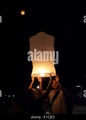 Teilnehmer bereiten, schwimmende Laternen in die Luft während der Yi Peng Festival in Luang Prabang, Laos zu starten. Stockfoto