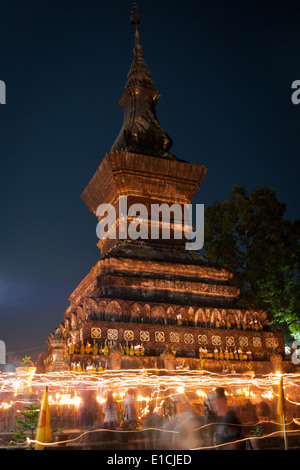 Bürgerinnen und Bürger zu verehren und marschieren mit Kerzen und Laternen um buddhistische Stupa während der Yi Peng Festival in Luang Prabang, Laos. Stockfoto