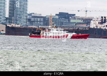 Kanadische Küstenwache Schiff der Corporal Teather CV Reisen am Lake Ontario vorbei Frachter an den Docks. Stockfoto