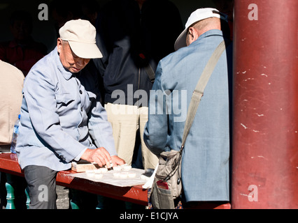 Zwei alte Mann im chinesischen Schach spielen im Freien, Beijing Stockfoto