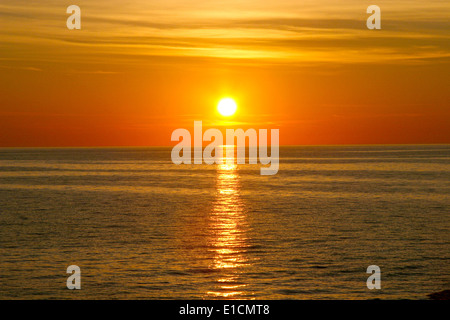 Schöne goldene orange Sonnenuntergang über dem Ozean. Die Sonne setzt, drehen die Himmel gelb, orange & roten Tönen & spiegelt sich in den Ozean. Stockfoto