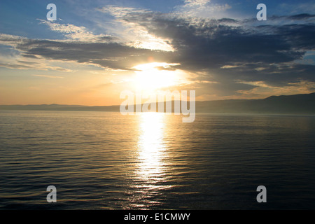 Sonnenuntergang über dem Meer mit der Küste im Hintergrund. Auf den Wellen, Karibische Meer das Sonnenlicht reflektiert. Stockfoto