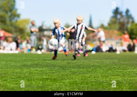 Verschwommene Aufnahme von Kinder spielen Fußball im Freien an einem sonnigen Tag. Stockfoto