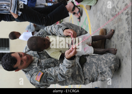 US Armee Sgt. 1. Klasse Arier Santiago haitianische Kinder lehrt, wie man im Solidante Fraternité Waisenhaus in Port - Seil springen Stockfoto