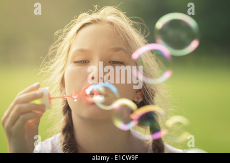 junges Mädchen bläst Seifenblasen im Park, im Sommer Stockfoto