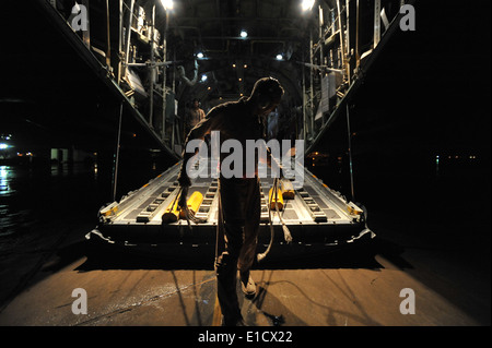US Air Force Senior Master Sergeant Archie Brawton bereitet sich auf Kreiden unter einer c-130 Hercules-Flugzeuge nach seiner Ankunft am Platz Stockfoto