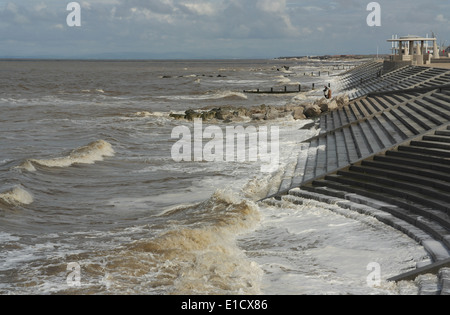 Sonnige graue Wolken anzeigen, Norden zu Rossall, Flut Meereswellen brechen, Buhnen und Schritte Cleveleys Promenade, Fylde Küste, UK Stockfoto