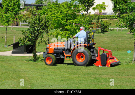 Gärtner auf eine Fahrt auf Mäher Rasenmähen an der National Memorial Arboretum, Alrewas, UK. Stockfoto