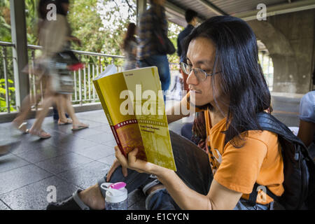 Bangkok, Bangkok, Thailand. 31. Mai 2014. Ein Mann sitzt auf dem Skywalk zwischen den BTS Skytrain Siam und Chit Lom Stationen leise Orwells "1984" und andere Bücher über zivilen Ungehorsam und gewaltlosen Protest zu lesen. Die Proteste basieren auf der '' Mann stehend '' Proteste, die letzten Sommer in der Türkei begonnen. Die Behörden gaben sich keine Mühe, den Protest zu stoppen oder stören die Menschen, die lasen. Bangkok war meist ruhigen Samstag. Es gab nur ein paar vereinzelte Proteste gegen den Putsch und die Militärregierung. © Jack Kurtz/ZUMAPRESS.com/Alamy Live-Nachrichten Stockfoto