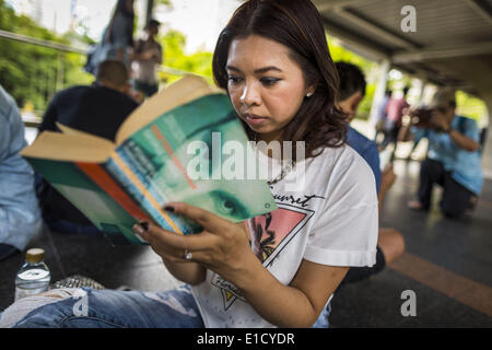 Bangkok, Bangkok, Thailand. 31. Mai 2014. Eine Frau sitzt in den Skywalk zwischen den BTS Skytrain Siam und Chit Lom Stationen leise Orwells "1984" und andere Bücher über zivilen Ungehorsam und gewaltlosen Protest zu lesen. Die Proteste basieren auf der '' Mann stehend '' Proteste, die letzten Sommer in der Türkei begonnen. Die Behörden gaben sich keine Mühe, den Protest zu stoppen oder stören die Menschen, die lasen. Bangkok war meist ruhigen Samstag. Es gab nur ein paar vereinzelte Proteste gegen den Putsch und die Militärregierung. © Jack Kurtz/ZUMAPRESS.com/Alamy Live-Nachrichten Stockfoto