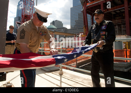 NEW YORK--Marine Master Sgt. William Gibson, Jr., hilft eine amerikanische Flagge, Falten, nachdem es das World Trade Center const überflogen Stockfoto