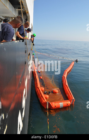 U.S. Coast Guard Besatzungsmitglieder, die USCGC Eiche (WLB 211) zugewiesen Platzieren der Weir-Abschäumer in der Spitze des Auslegers, während Öl s Stockfoto