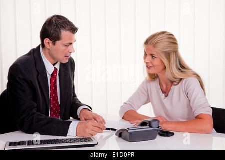 Junge Frau unterzeichnet einen Vertrag in einem Büro Stockfoto