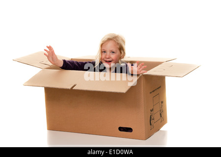 Kind im Karton. Liegt in der Box, beim bewegen. Stockfoto