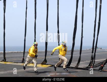 Flight Deck Offiziere an Bord des Flugzeugträgers USS Dwight D. Eisenhower (CVN-69) laufen über das Flugdeck während einer barricad Stockfoto