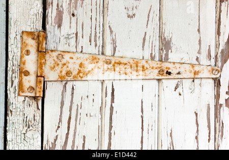 großen verrosteten Metall Scharnier auf peeling Holztür Stockfoto