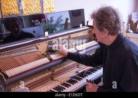 Tuner bei der Arbeit mit Ratsche am Klavier Stockfoto