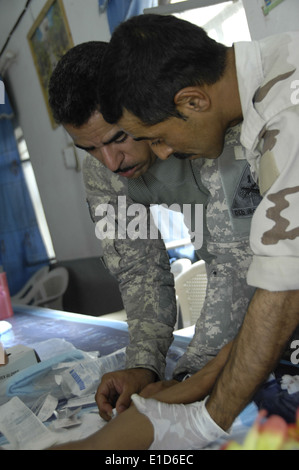 US Armee Sgt. 1. Klasse Julio Encarnacion überwacht ein irakischer Soldat mit der 10. Division der irakischen Armee, als er Admi bereitet Stockfoto