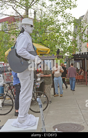 Asheville, North Carolina, USA - 26. April 2013: "Mann In weiß" eine lebende Statue darstellt und spielt Gitarre Tipps auf der Straße Stockfoto