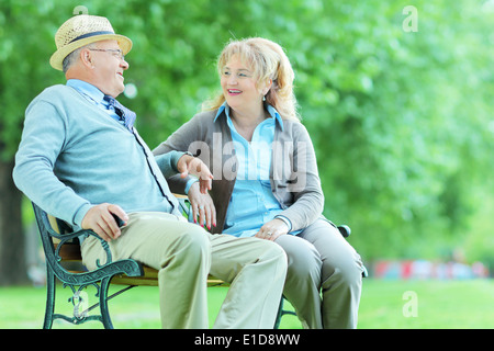 Älteres Paar auf Bank im Park sitzen im Gespräch Stockfoto