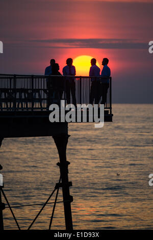 Aberystwyth Wales UK, Samstag, 31. Mai 2014 Gruppe Männer trinken und relaxen am Ende von Aberystwyths viktorianischen Pier Sonnenuntergang über Cardigan Bay auf der West Wales Küste Photo Credit: Keith Morris/Alamy Live-Nachrichten Stockfoto