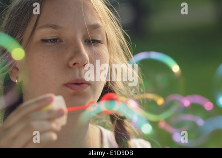 junges Mädchen bläst Seifenblasen im Park, im Sommer Stockfoto