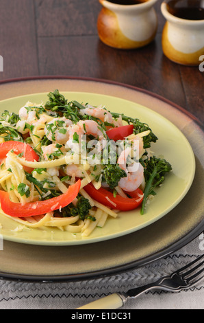 Linguine mit Garnelen, Broccolini und Paprika auf eine Holzoberfläche Stockfoto