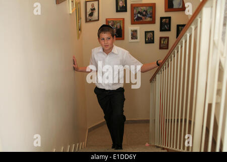 (140601)--JERUSALEM, 1. Juni 2014 (Xinhua)--Tzviel Noyman steht vor der Wand mit Familienfotos in seinem Haus in Beit Shemesh, etwa 20 km von Jerusalem, am 30. Mai 2014. Tzviel Noyman ist ein israelischer ultra-orthodoxen junge in einer Familie mit sechs Kindern, drei Buben und drei Mädchen. Er ist zehn Jahre alt, in diesem Jahr und ein Klasse drei Schüler Torat Moshe Elementary school, die nur für jüdische Kinder geöffnet ist. Tzviel hat 8 Klassen pro Tag, darunter Hebräisch, Englisch, Mathematik und jüdische Religion, die vier Klassen hat jeden Tag einschließlich der Talmud, Mischna und Gemara. Tzviel mag die Stockfoto