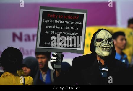 Jakarta, Indonesien. 1. Juni 2014. Ein Mann mit einer Maske hält ein Plakat während einer Gedenkfeier der Welttag ohne Tabak, markiert am 31. Mai in Jakarta, Indonesien, 1. Juni 2014. Indonesien, bleibt trotz aktiv an der Erarbeitung der Welt Gesundheit Organisation Framework Convention on Tobacco Control, das einzige Land, das nicht unterzeichnet und ratifiziert den Rahmen zwischen den Ländern des asiatisch-pazifischen Raum hat. Agung Kuncahya © B./Xinhua/Alamy Live-Nachrichten Stockfoto